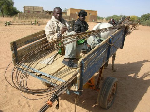 men carrying the metal for the well 30kms